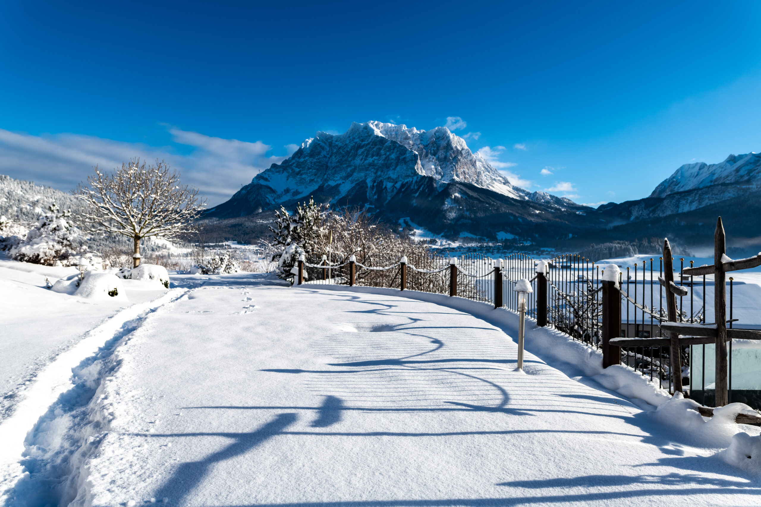Blick auf die verschneiten Berge bei Sonnenschein - Hotel Post 4*S