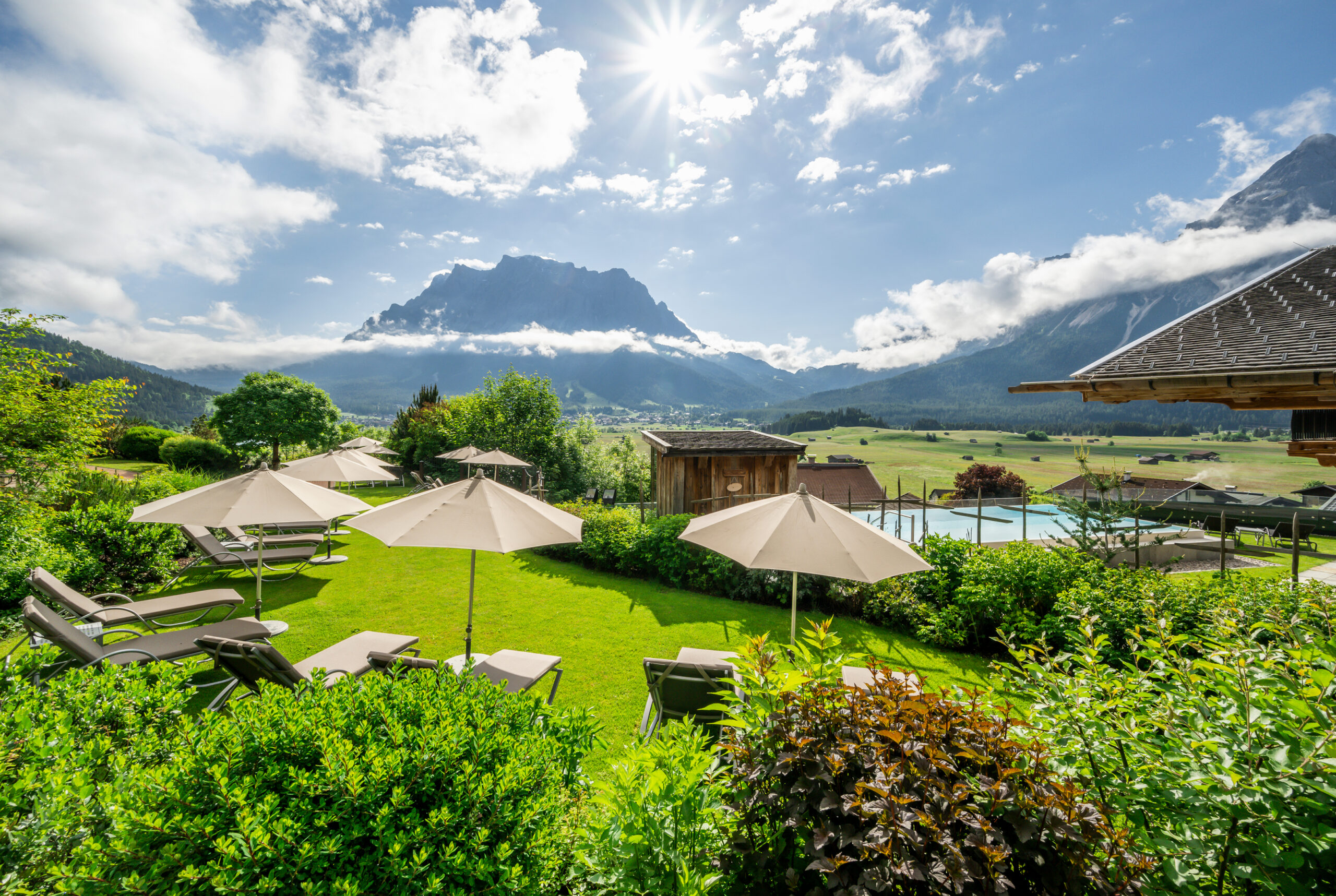 Garten mit Liegestühlen und weißen Sonnenschirmen