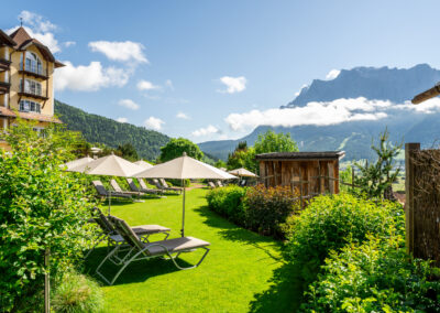 Liegen und weiße Sonnenschirme im Garten