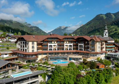 Hotel mit Bergen und Kirchturm dahinter
