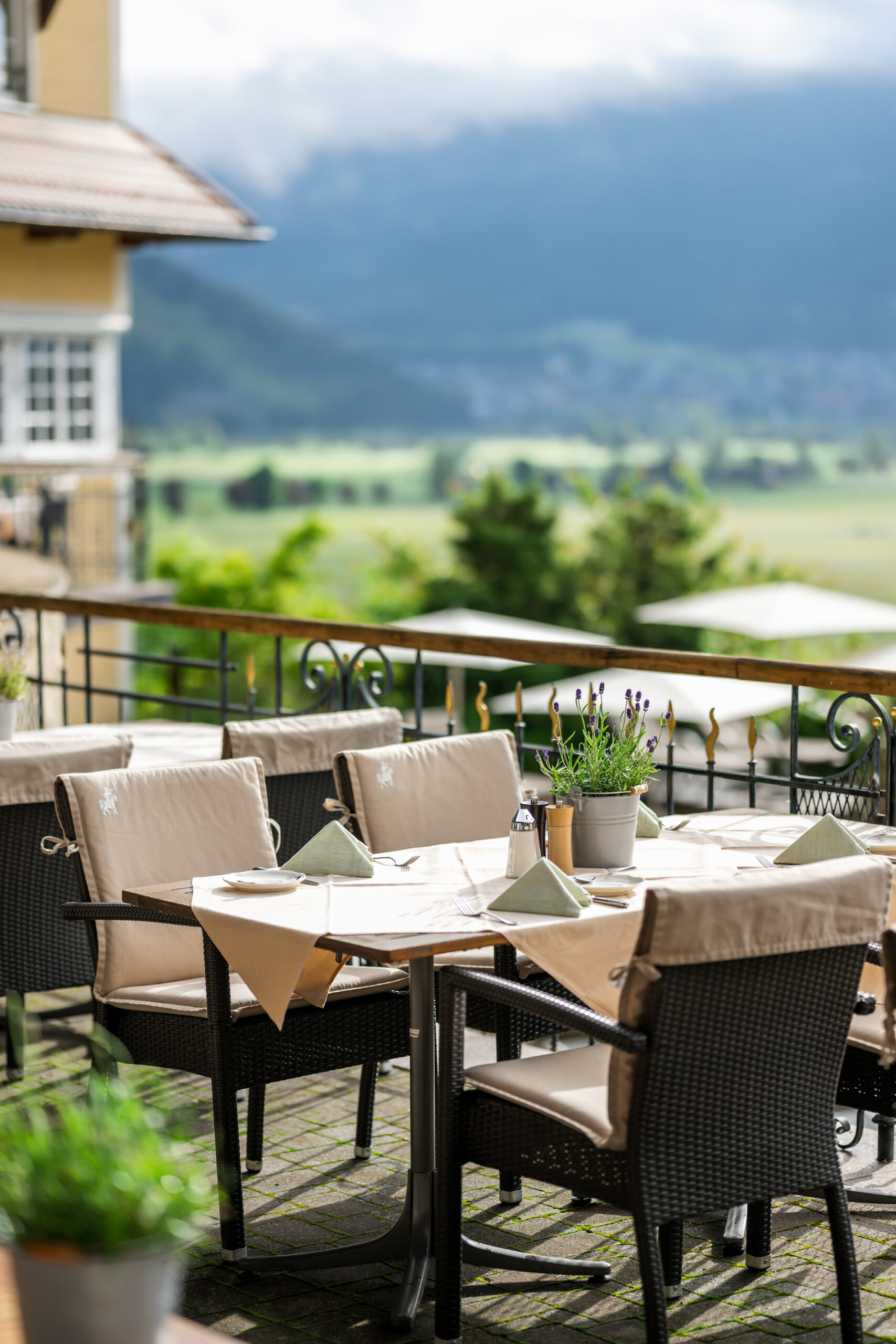 Terrasse mit Tisch, Tischtuch und Korbstühlen