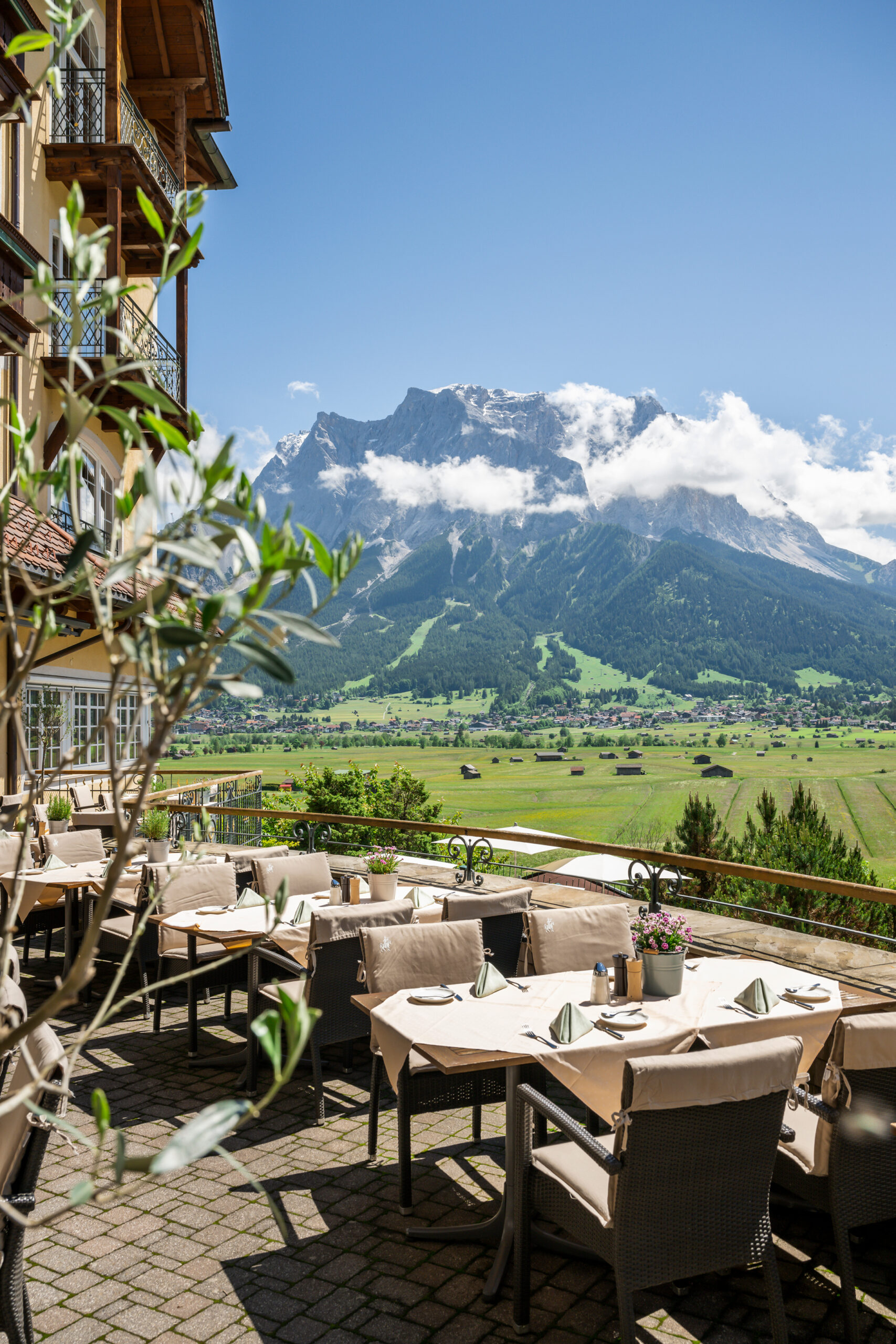 Gedeckte Tische auf Sonnenterrasse mit Bergblick - Hotel Post 4*S