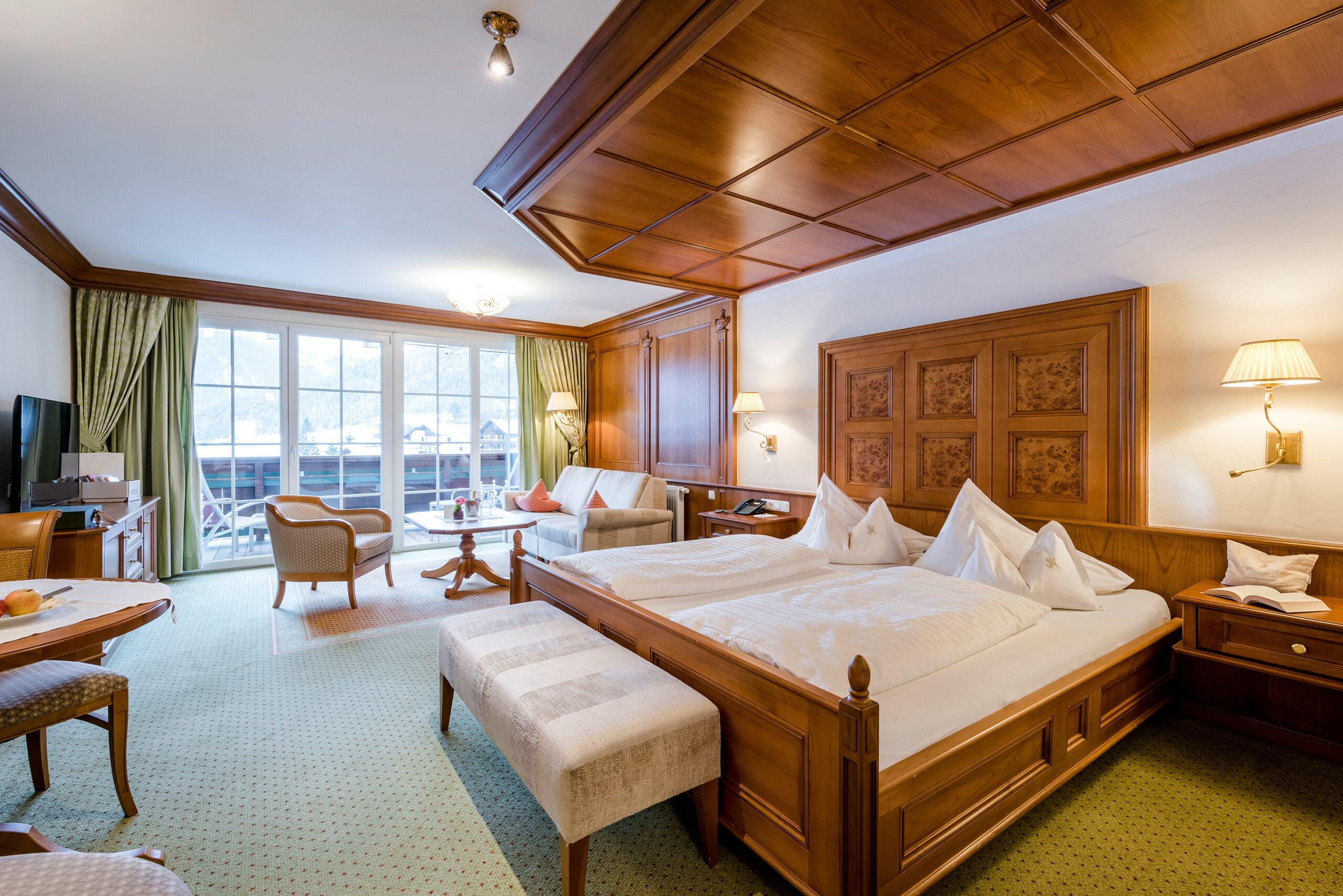 Zimmer mit Doppelbett und großen Fensterfronten