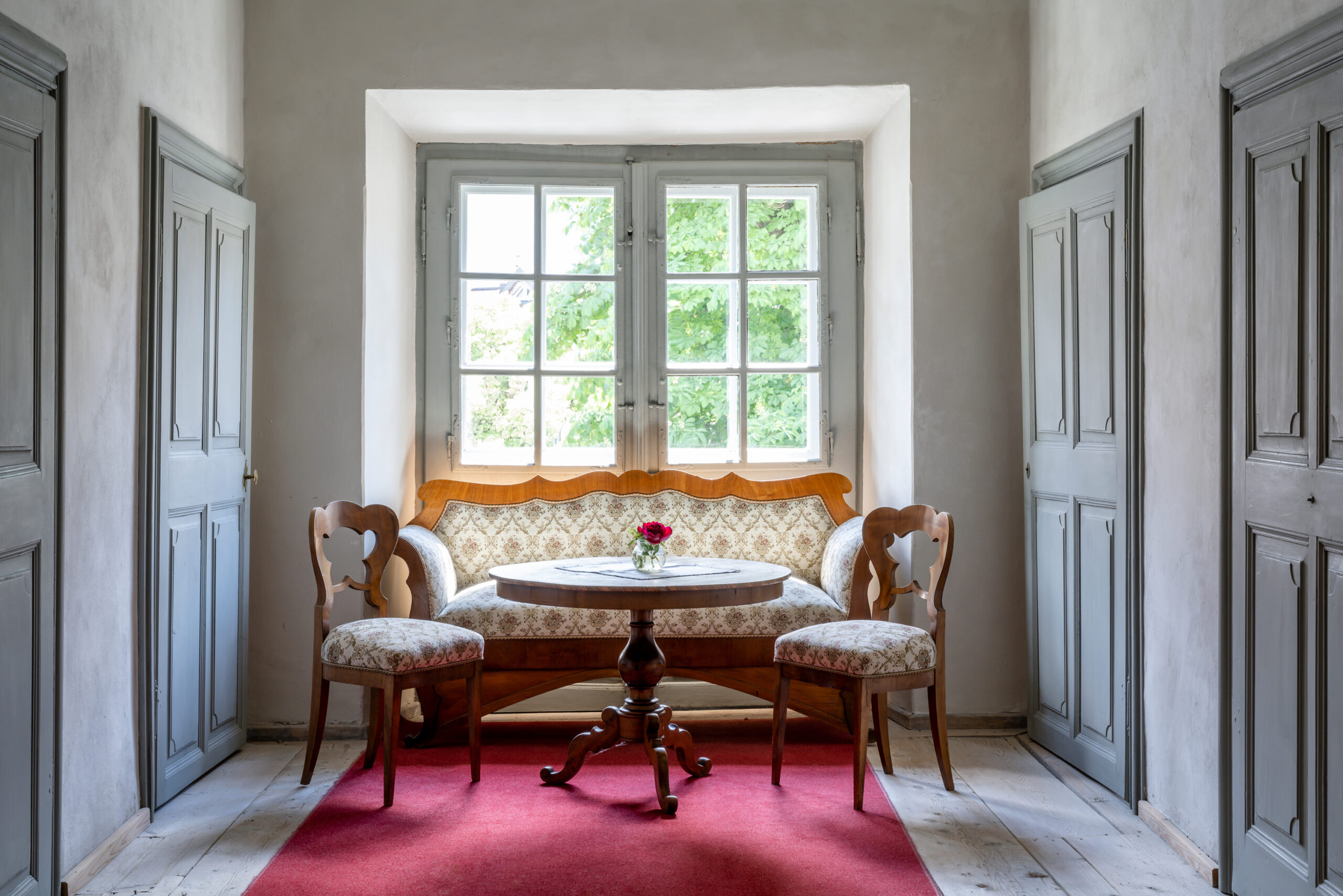 Sofa mit zwei Sesseln vor Fenster