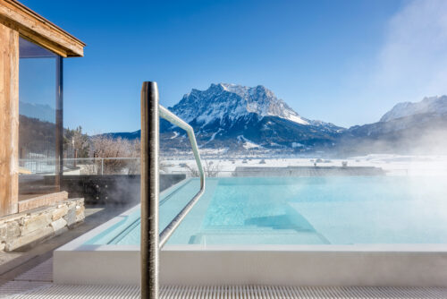 Dampfender Pool im Winter mit Bergkulisse