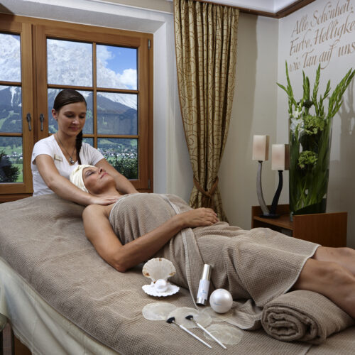 Dame liegt auf Liege erhält Massage