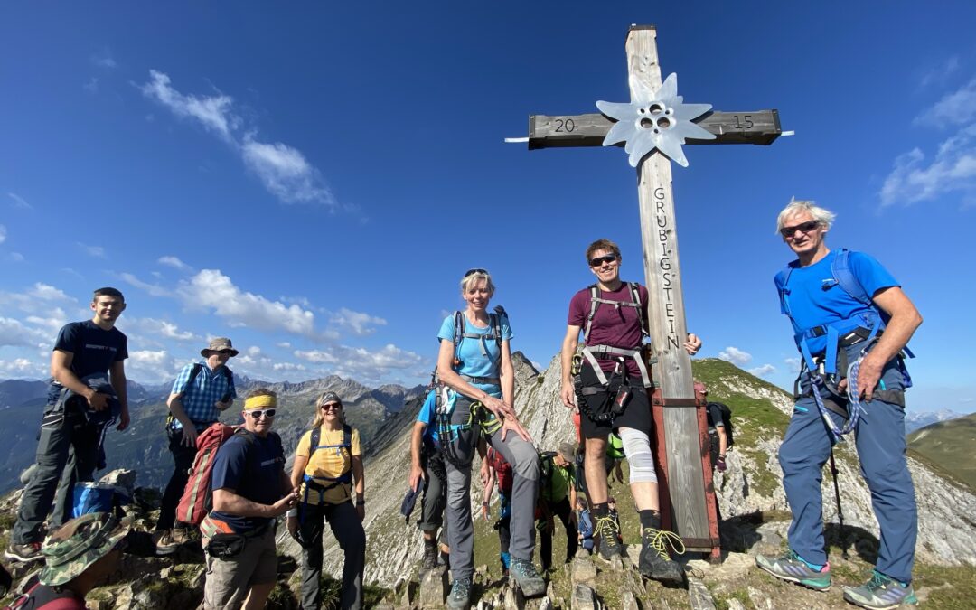 Gruppe Wanderer bei Gipfelkreuz