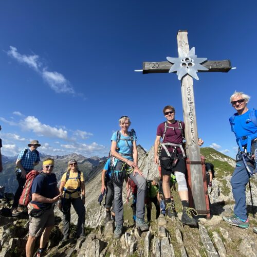 Gruppe Wanderer bei Gipfelkreuz