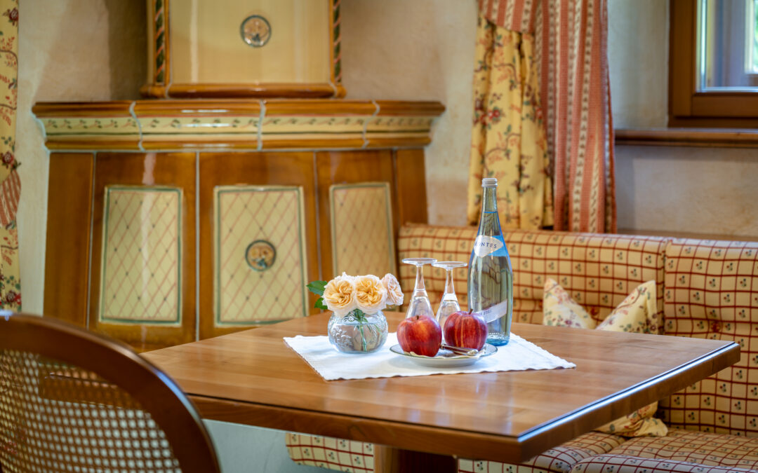 Mineralwasser, Gläser, Äpfel und Blumen auf Tisch